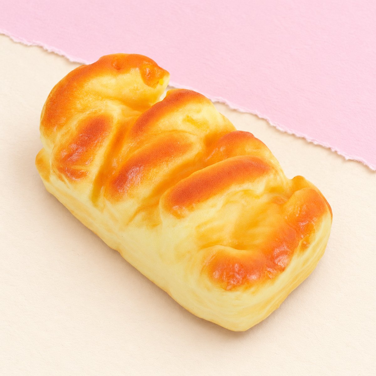 Squishy brioche de 11 cm sobre papel cor pastel