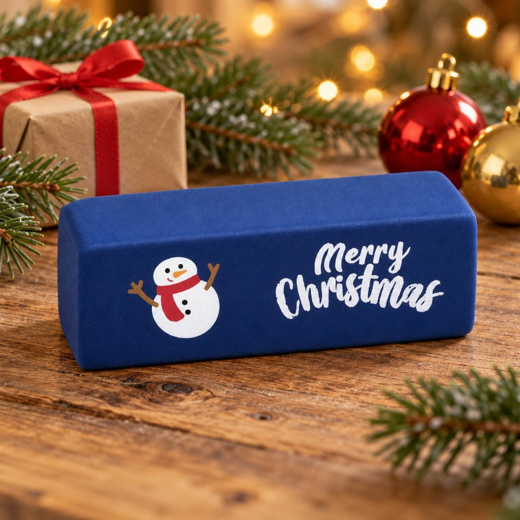 Squishy burro Merry Christmas blu scuro con pupazzo di neve tra rami di abete e lucine