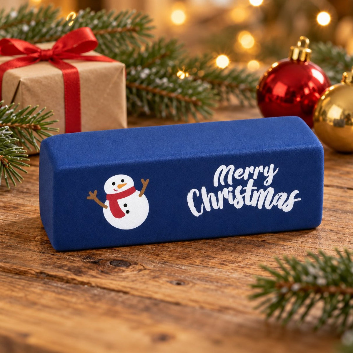 Squishy burro Merry Christmas blu scuro con pupazzo di neve tra rami di abete e lucine