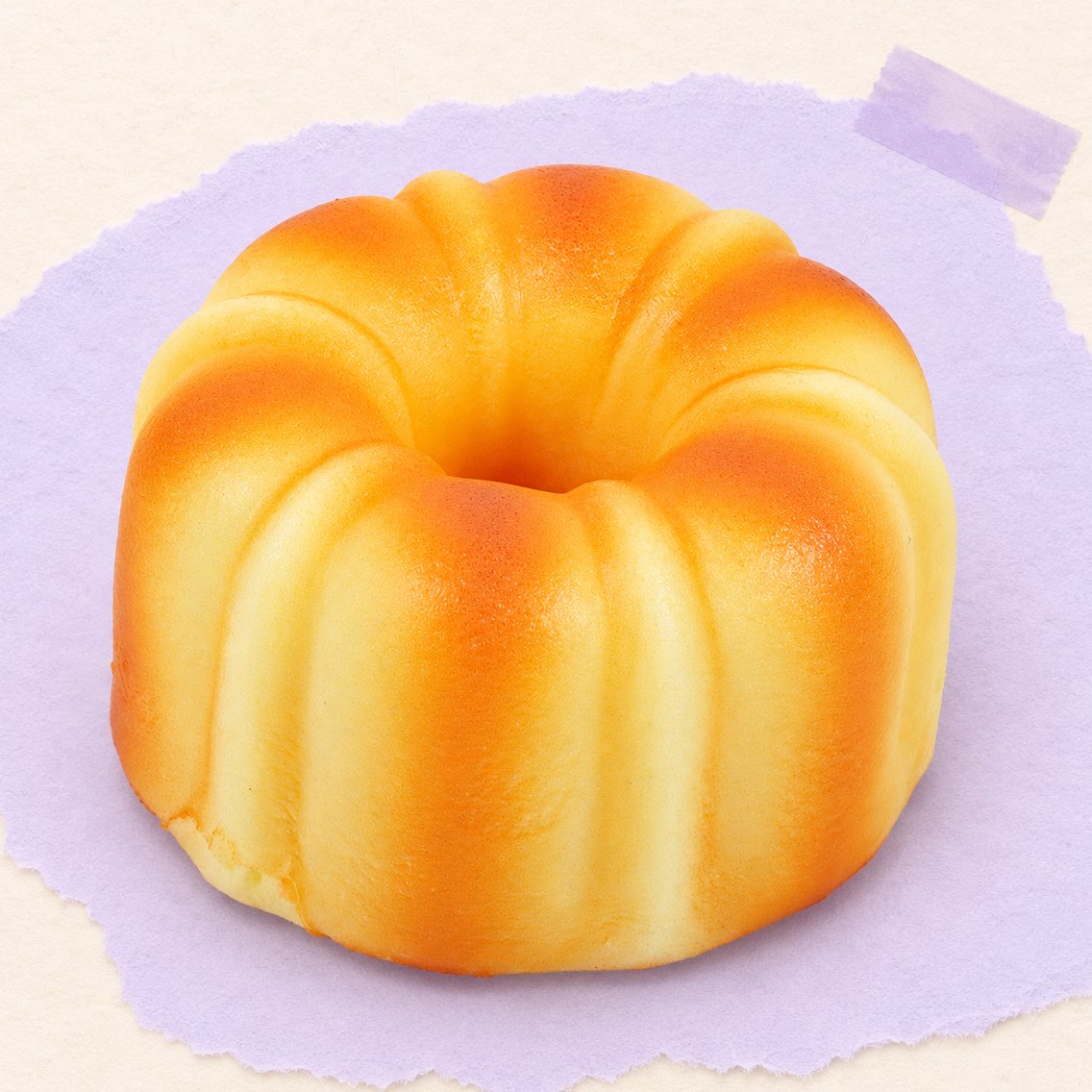 Squishy canelé, pastelito francés de 9 cm sobre papel pastel