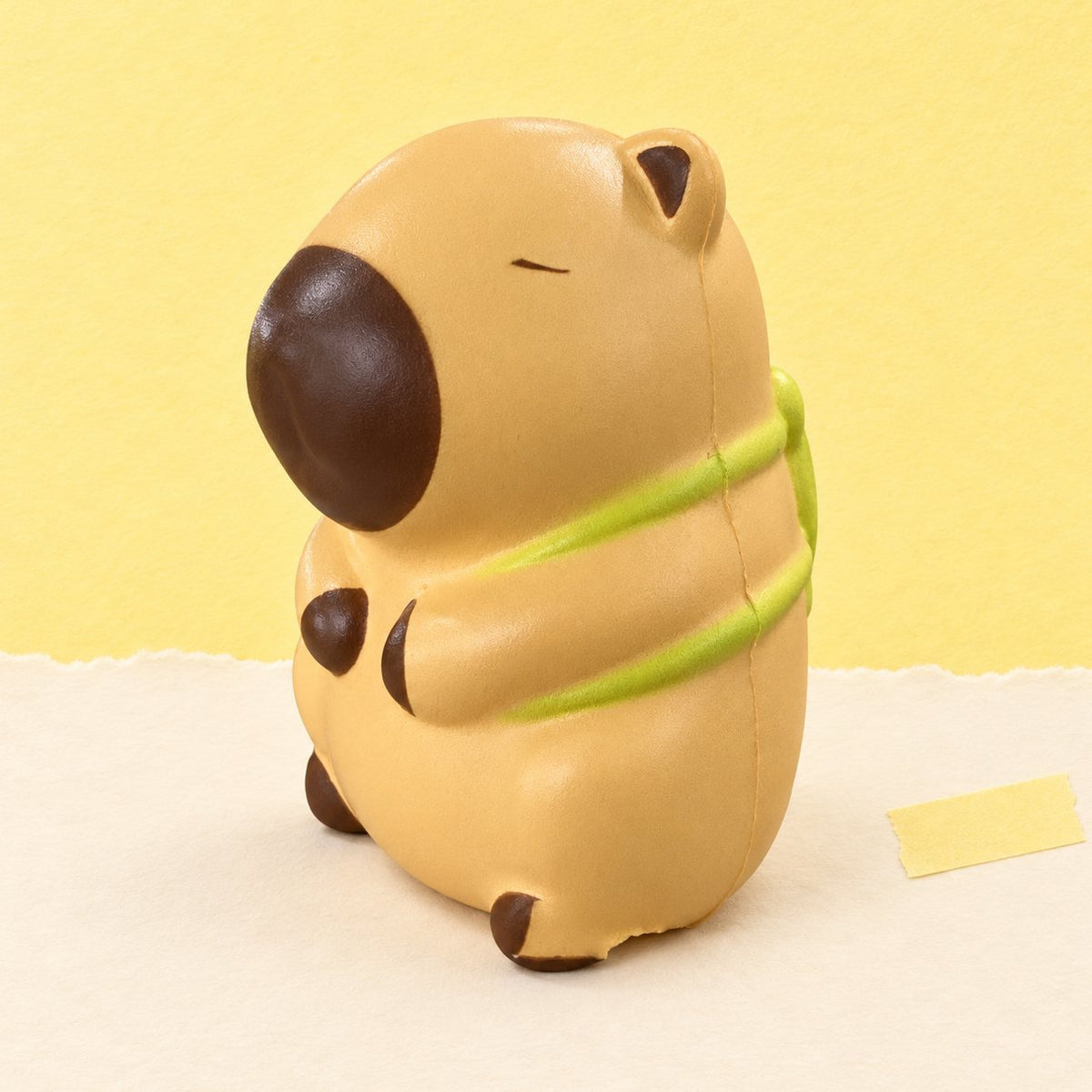 Squishy capibara slow rising con tortuga, beige claro, sobre papel pastel