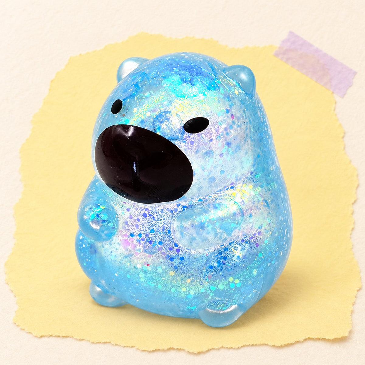 Squishy capybara à paillettes bleu, style sucre, sur papier pastel