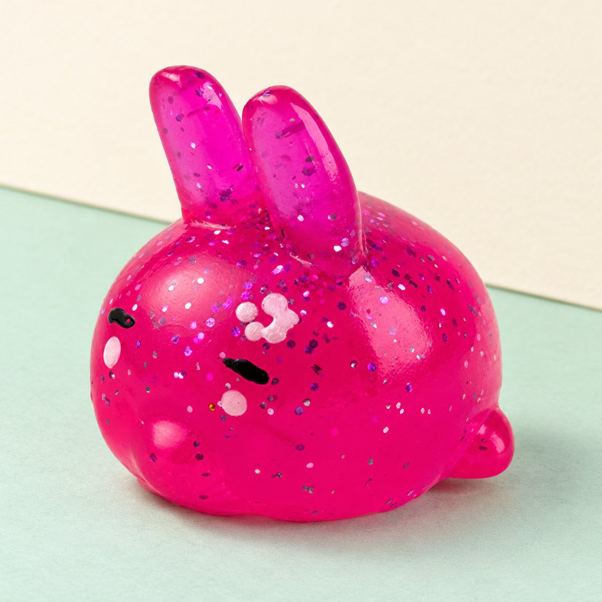 Squishy coniglietto con glitter, foto del prodotto su carta pastello