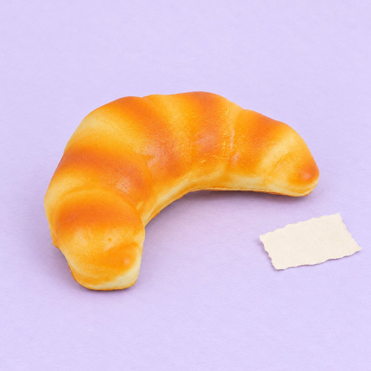 Squishy croissant 12,5 cm, realistyczne pieczywo slow rising na pastelowym tle