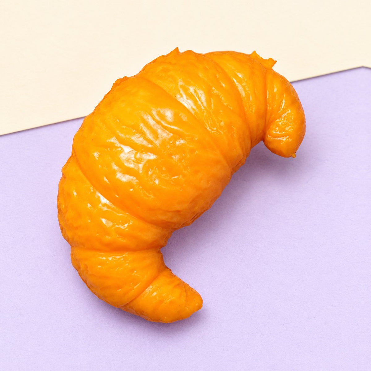 Squishy crunchy de cruasán hecho a mano, sobre papel pastel