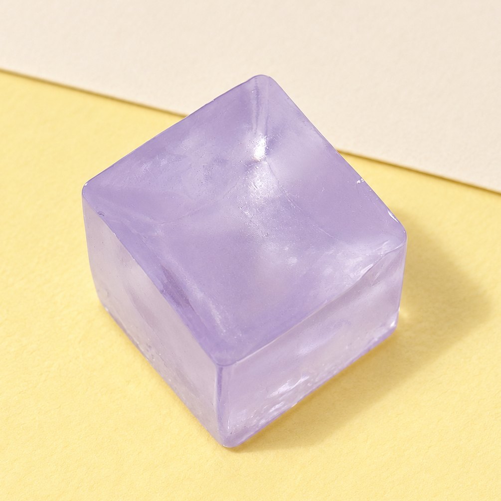 Squishy cubito de hielo mini lila, de 2,5 cm, sobre papel pastel
