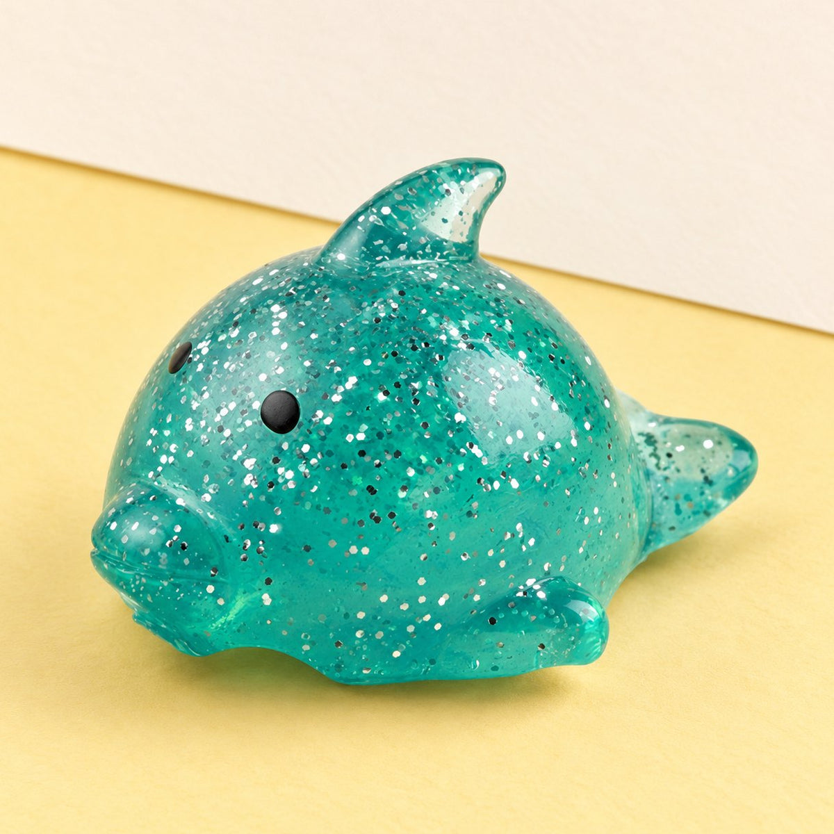 Grand squishy dauphin mochi à paillettes, photo produit sur papier pastel