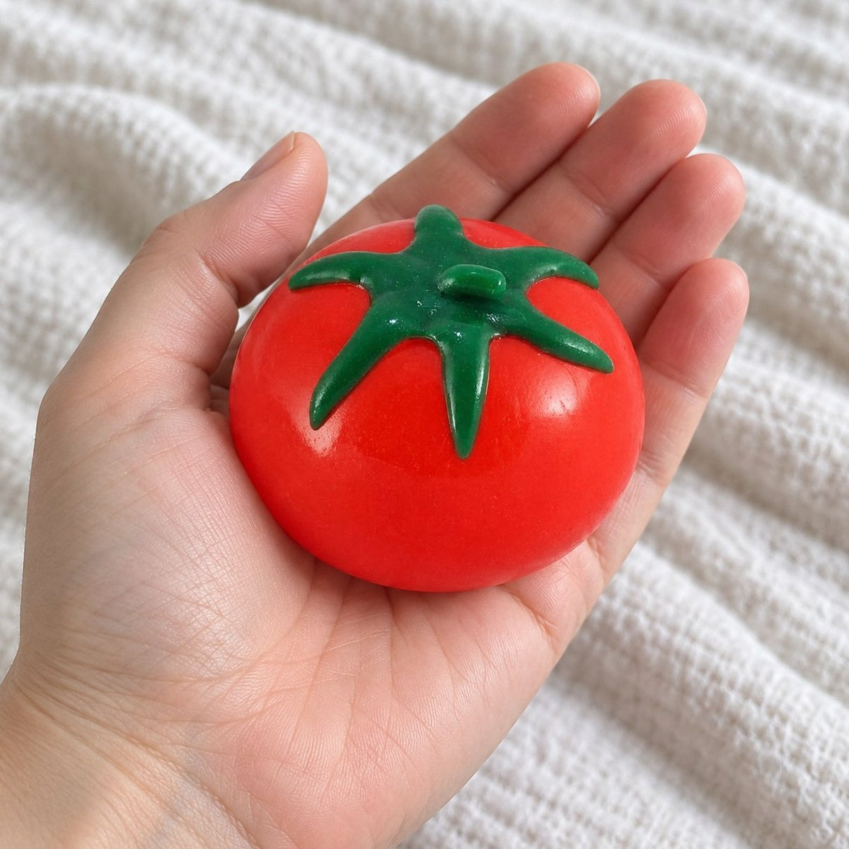 Squishy de agua con forma de fruta tomate, visto en primera persona