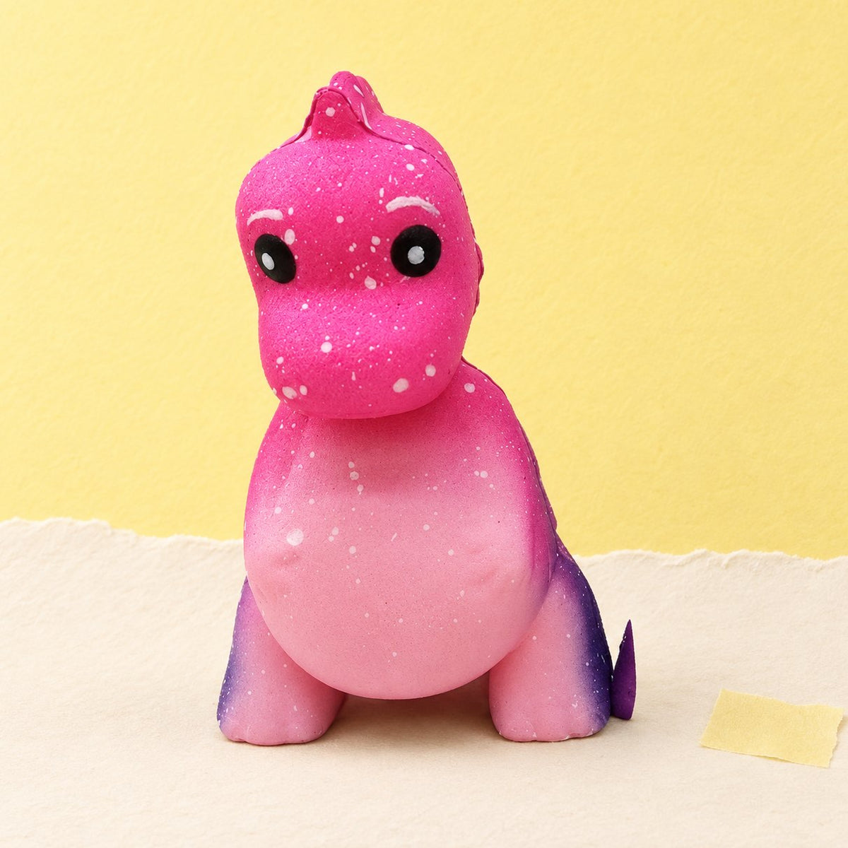 Squishy dinosauro galassia rosa da 10,5 cm su carta color pastello