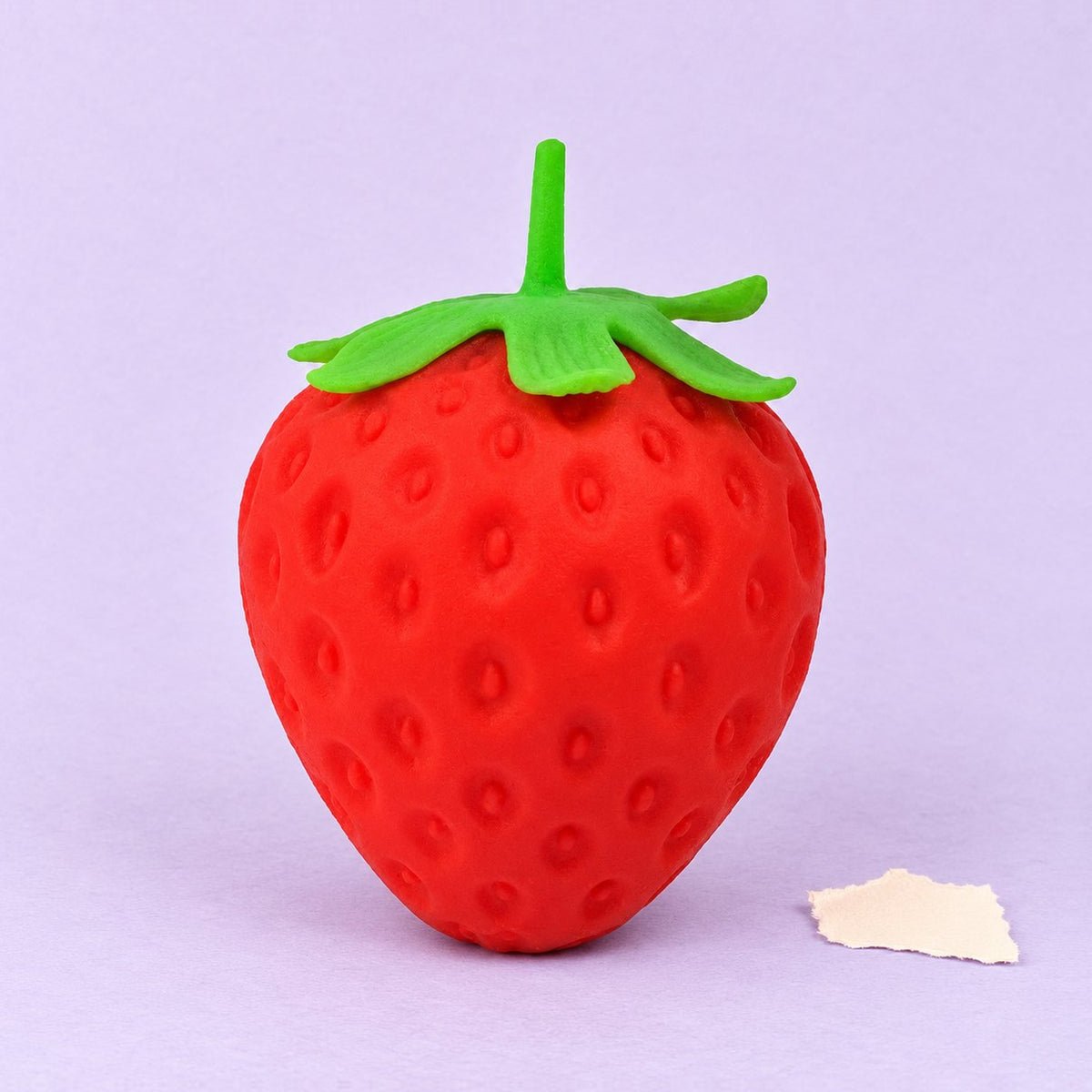 Squishy de fresa gigante, slow rising, sobre papel pastel