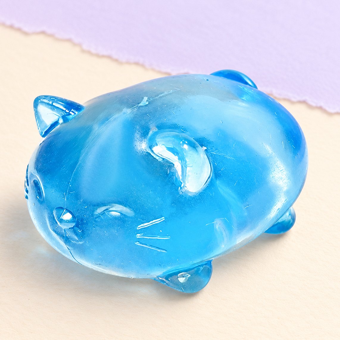 Squishy gato de gelatina em maltose transparente, cor azul, sobre papel pastel