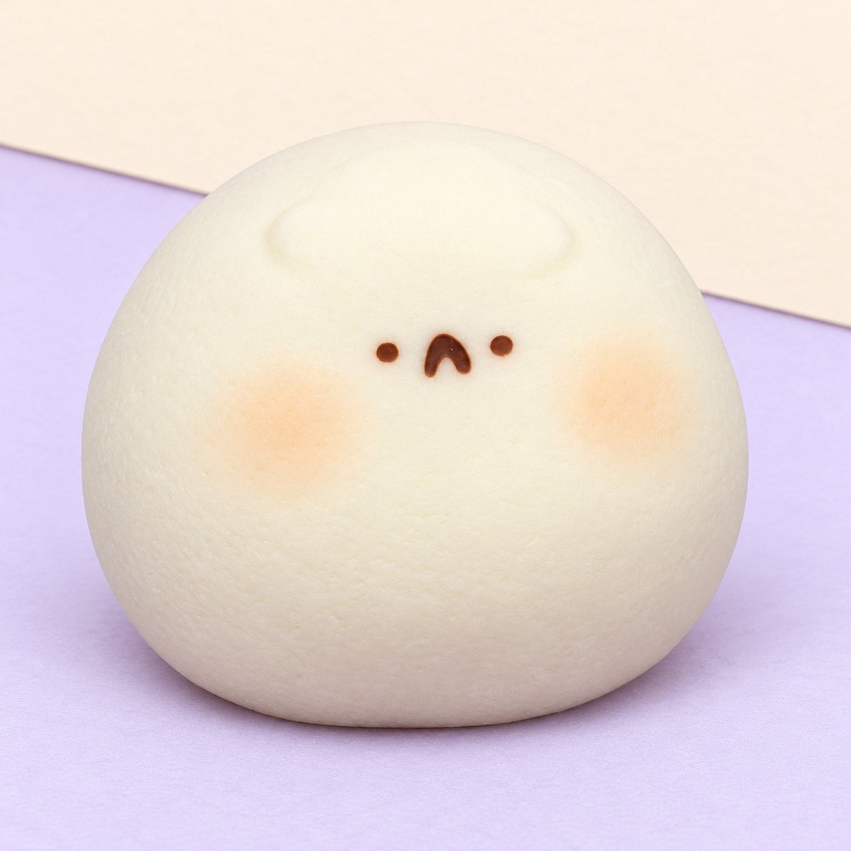 Squishy hámster daifuku blanco, extrablando, sobre papel pastel