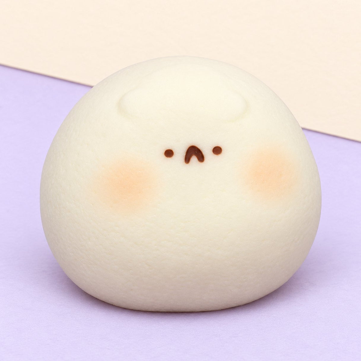 Squishy hamster taba blanc, daifuku extra doux posé sur un papier pastel