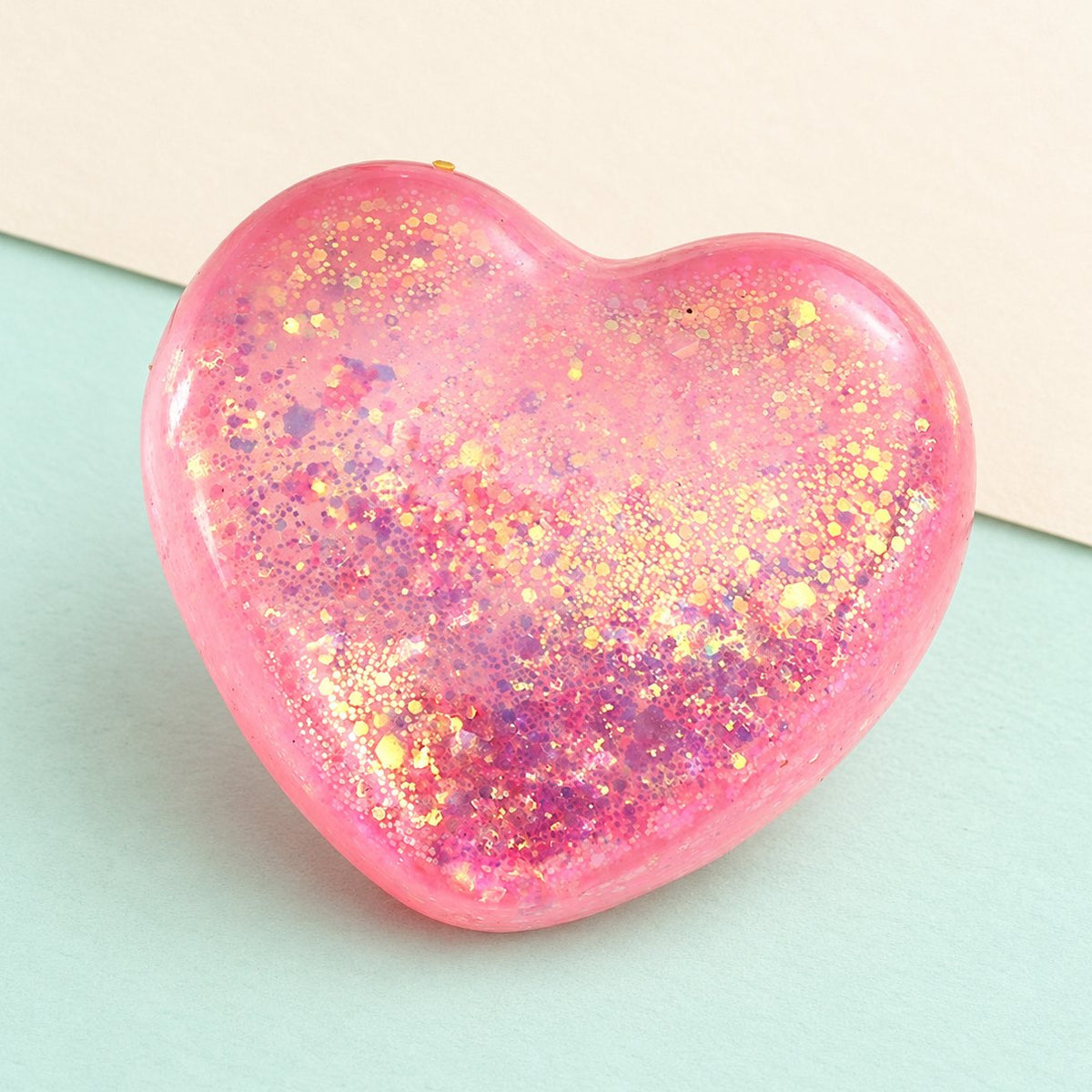 Herz Squishy mit Glitzer im Maltose-Stil, 6,7 cm, rosa, auf Pastellpapier