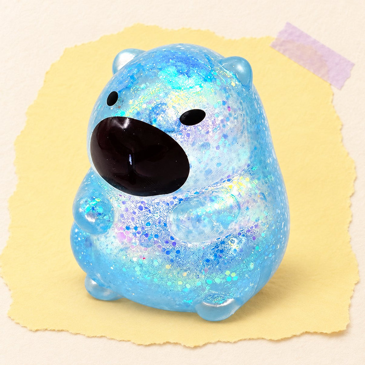 Niebieski squishy kapibara z brokatem w stylu sugar na pastelowym tle