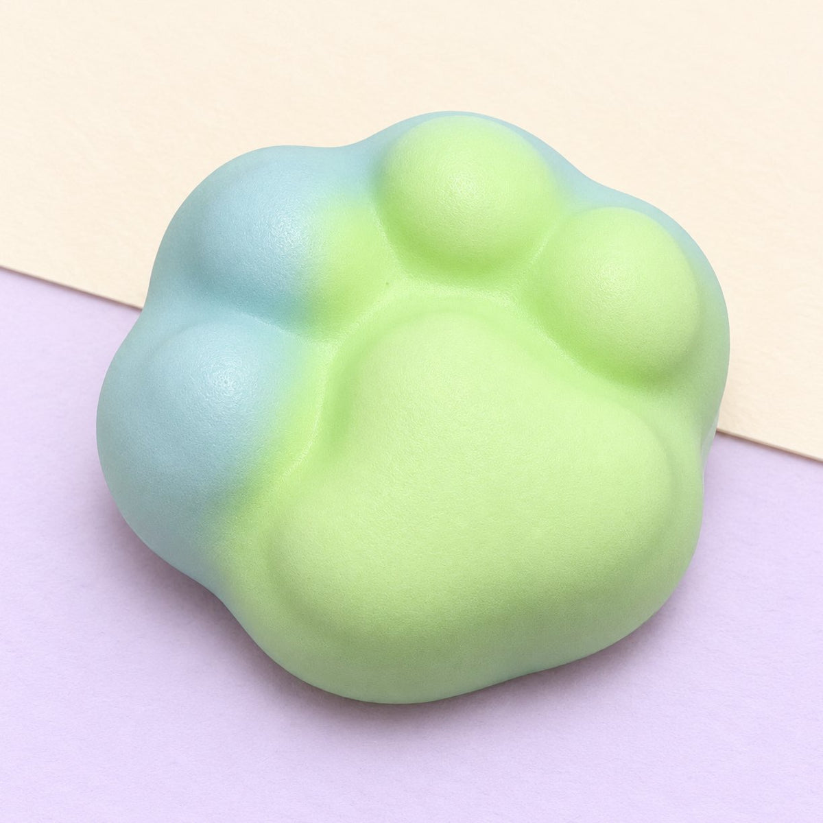 Squishy kočičí tlapka mini, 6 cm v zelené barvě, na pastelovém papíře
