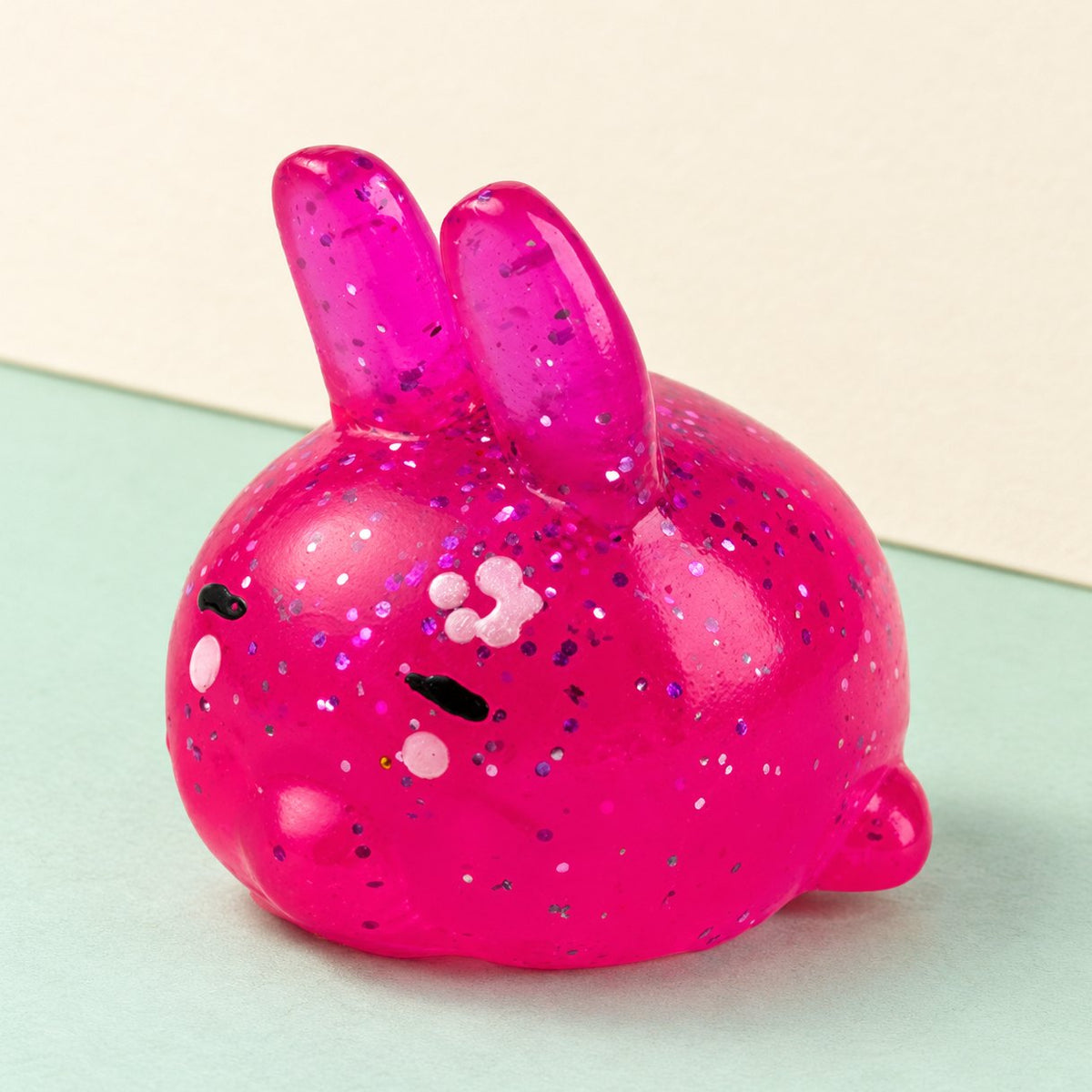 Squishy lapin mochi à paillettes sur fond de papier pastel