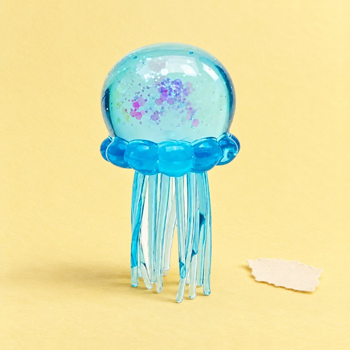 Squishy medusa azul de TPR blando sobre papel pastel