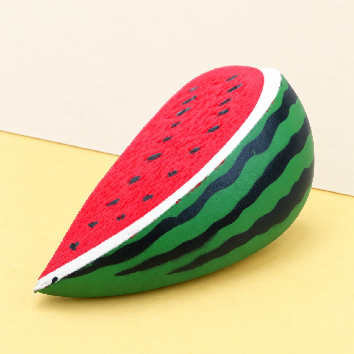 Squishy melancia slow rising em PU, fotografado sobre papel pastel