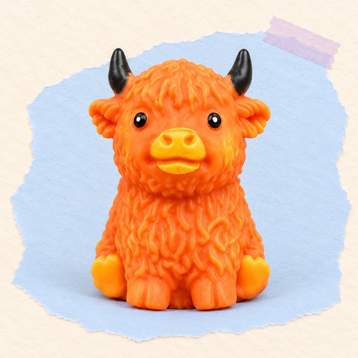 Squishy mucca highland crunchy arancio-marrone fotografato su carta color pastello