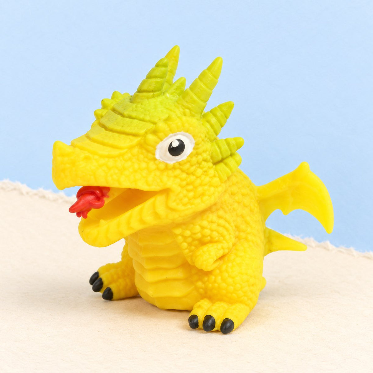 Squishy obrácecí dinosauří vejce, žluté s náhodným dinem, na pastelovém papíře