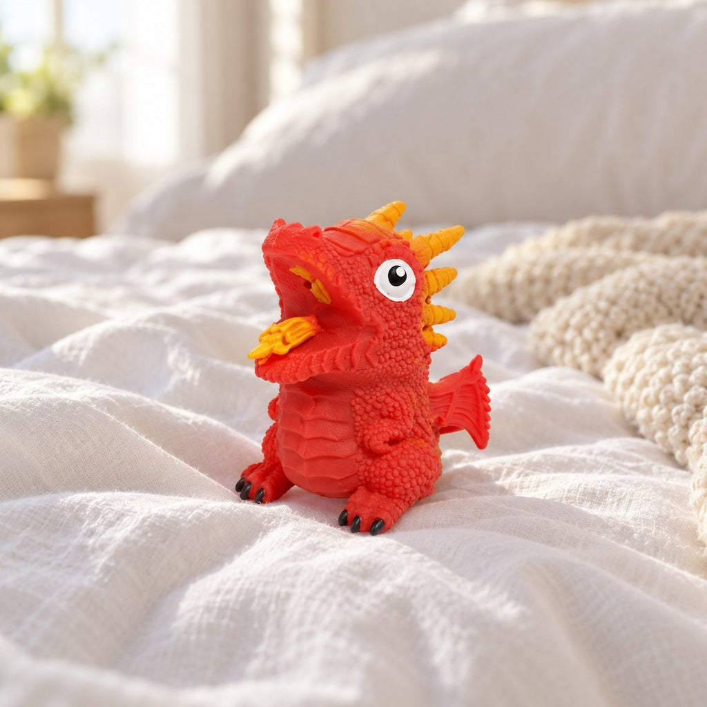 Červené squishy obrácecí dinosauří vejce s náhodným dinem na útulné posteli s měkkými dekami