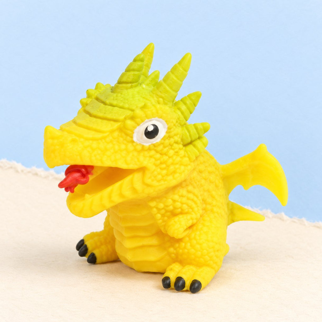 Squishy œuf de dinosaure réversible jaune, modèle de dino au hasard, sur papier pastel