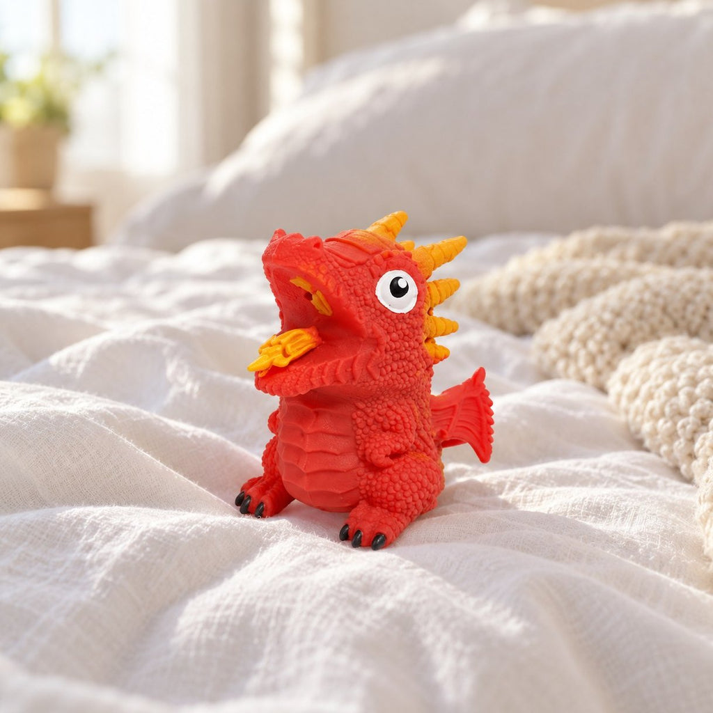 Squishy œuf de dinosaure réversible rouge posé sur un lit douillet