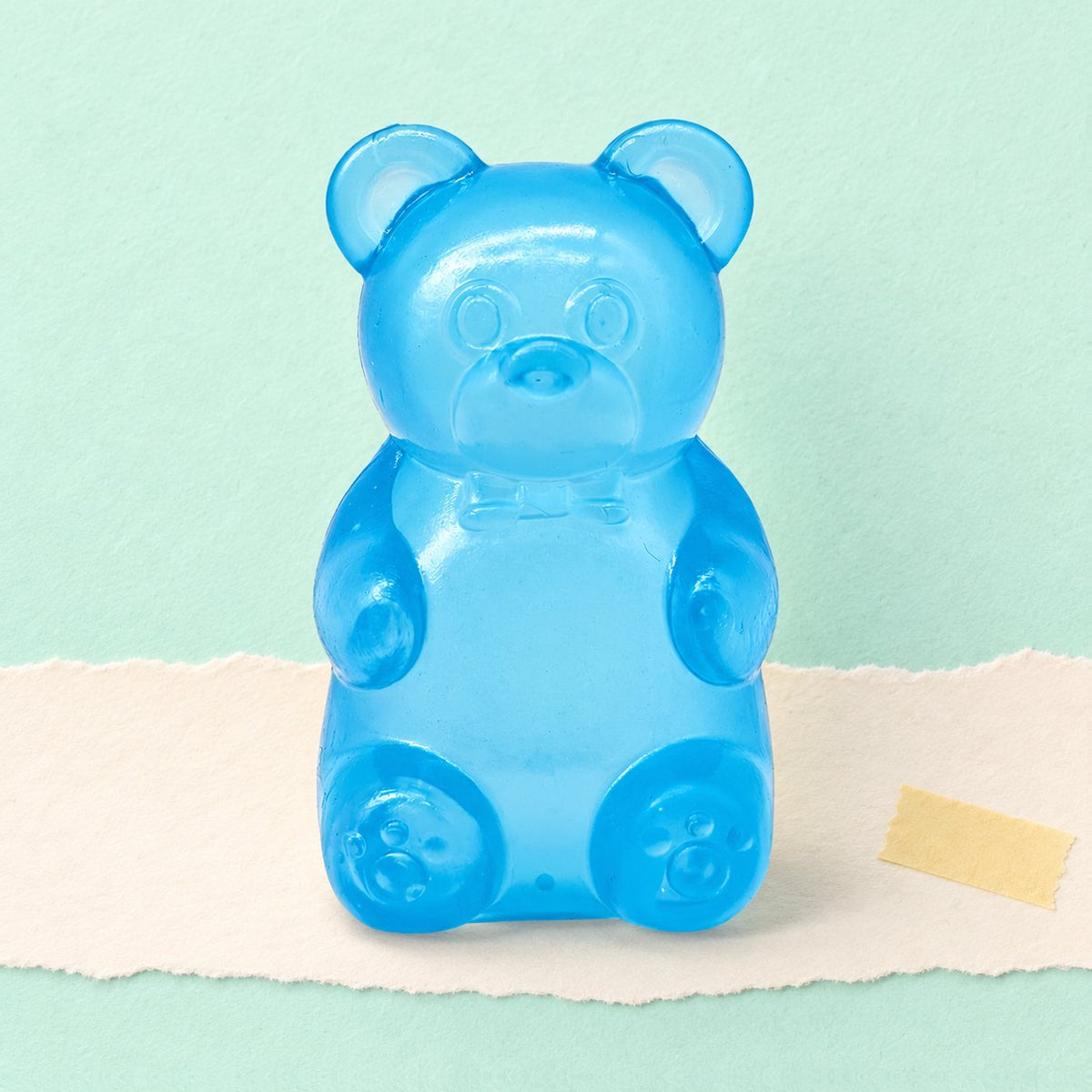 Squishy orsetto gommoso blu fotografato su carta color pastello