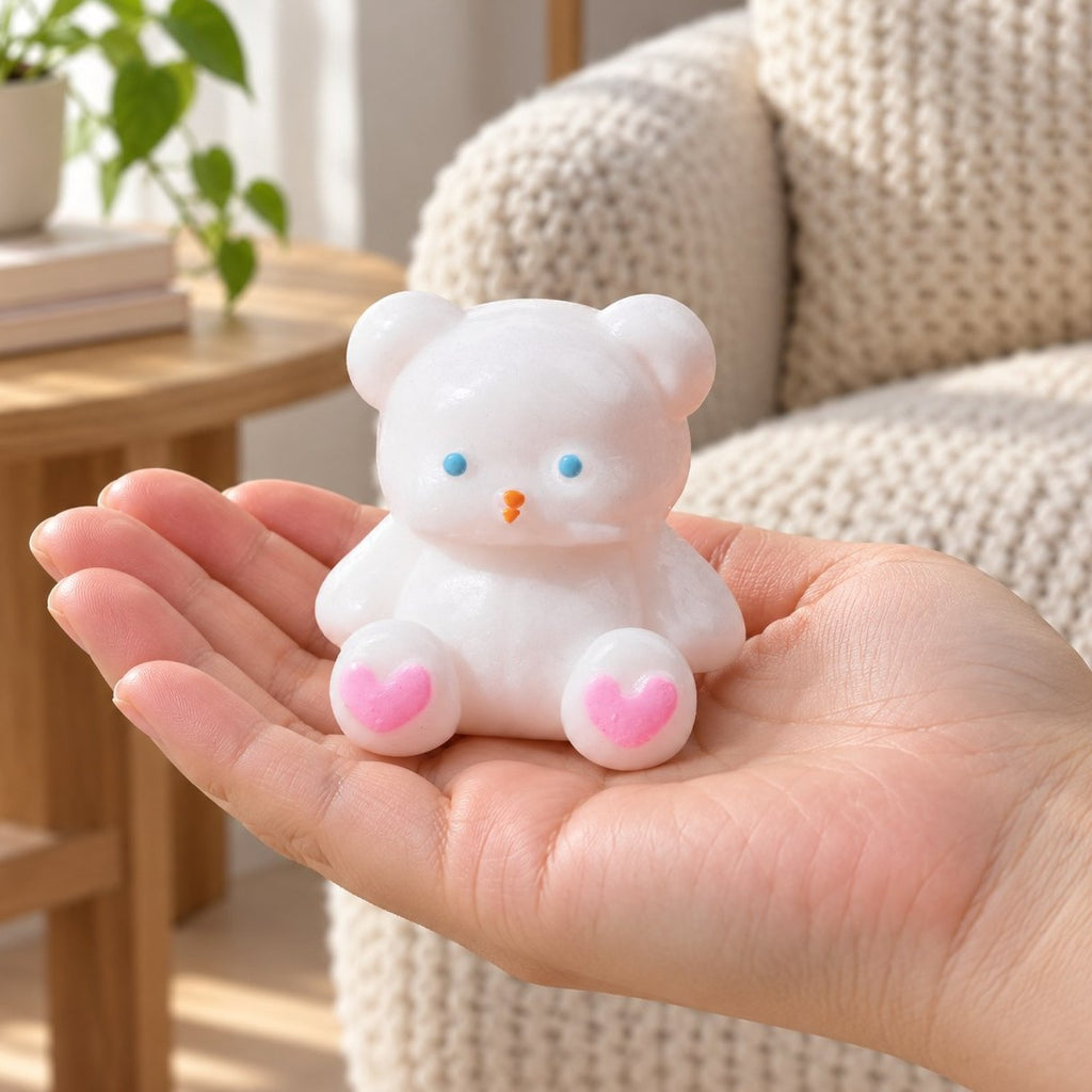 Squishy osito blanco con patas de corazón de 7 cm en la mano, a tamaño real