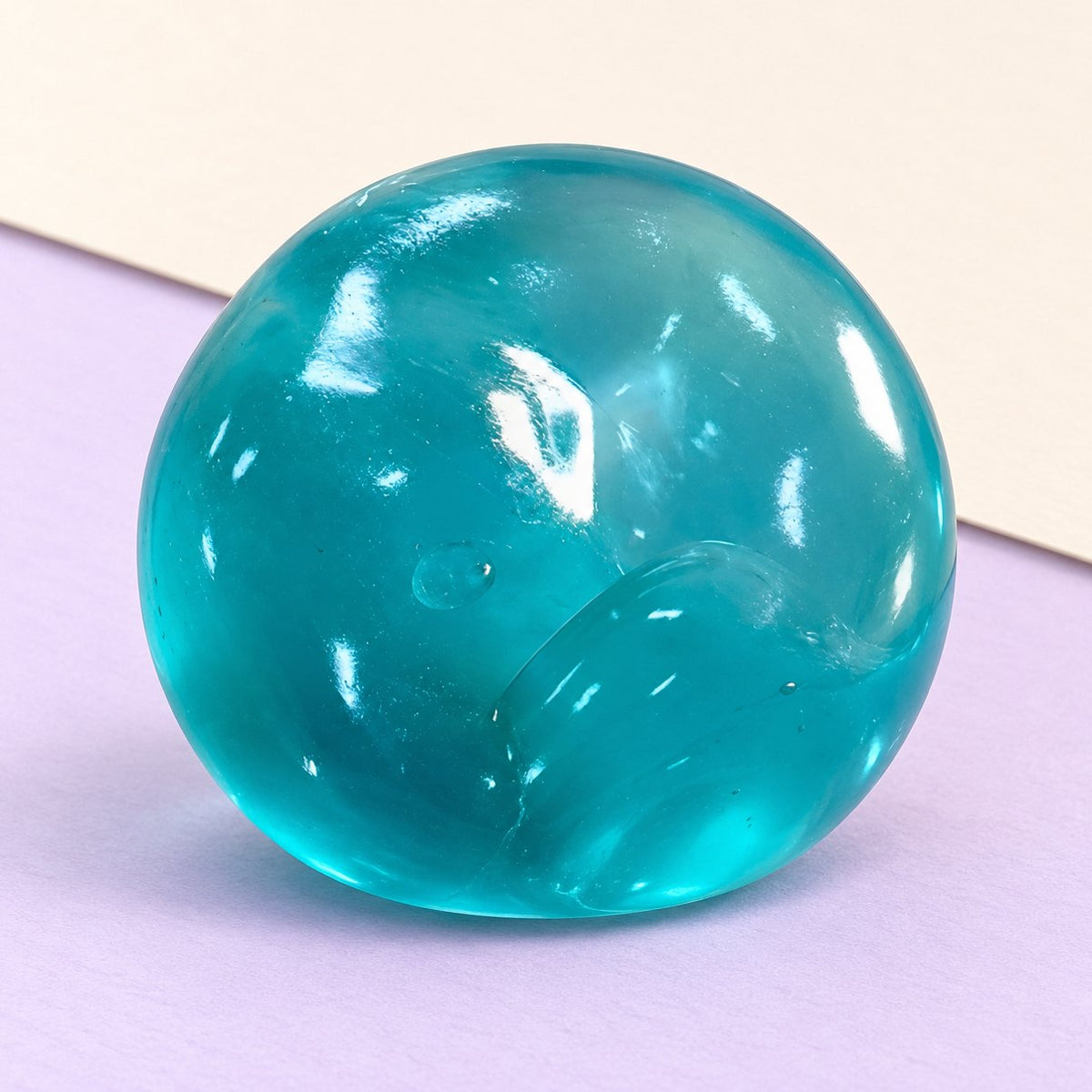 Squishy pallina di maltosio blu oceano slow rising in gel fotografato su carta color pastello