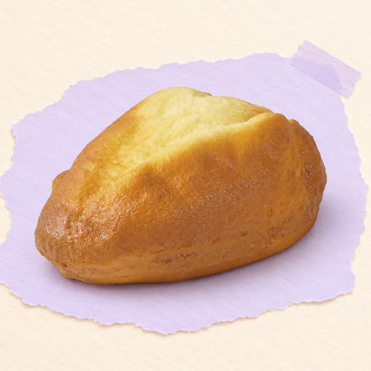 Squishy pan de payés, hogaza dorada de 16 cm sobre papel pastel