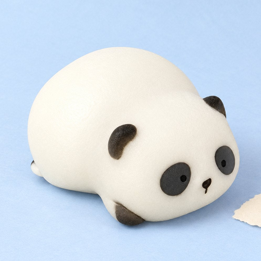 Panda Squishy, liegend in einer Geschenkbox, auf Pastellpapier