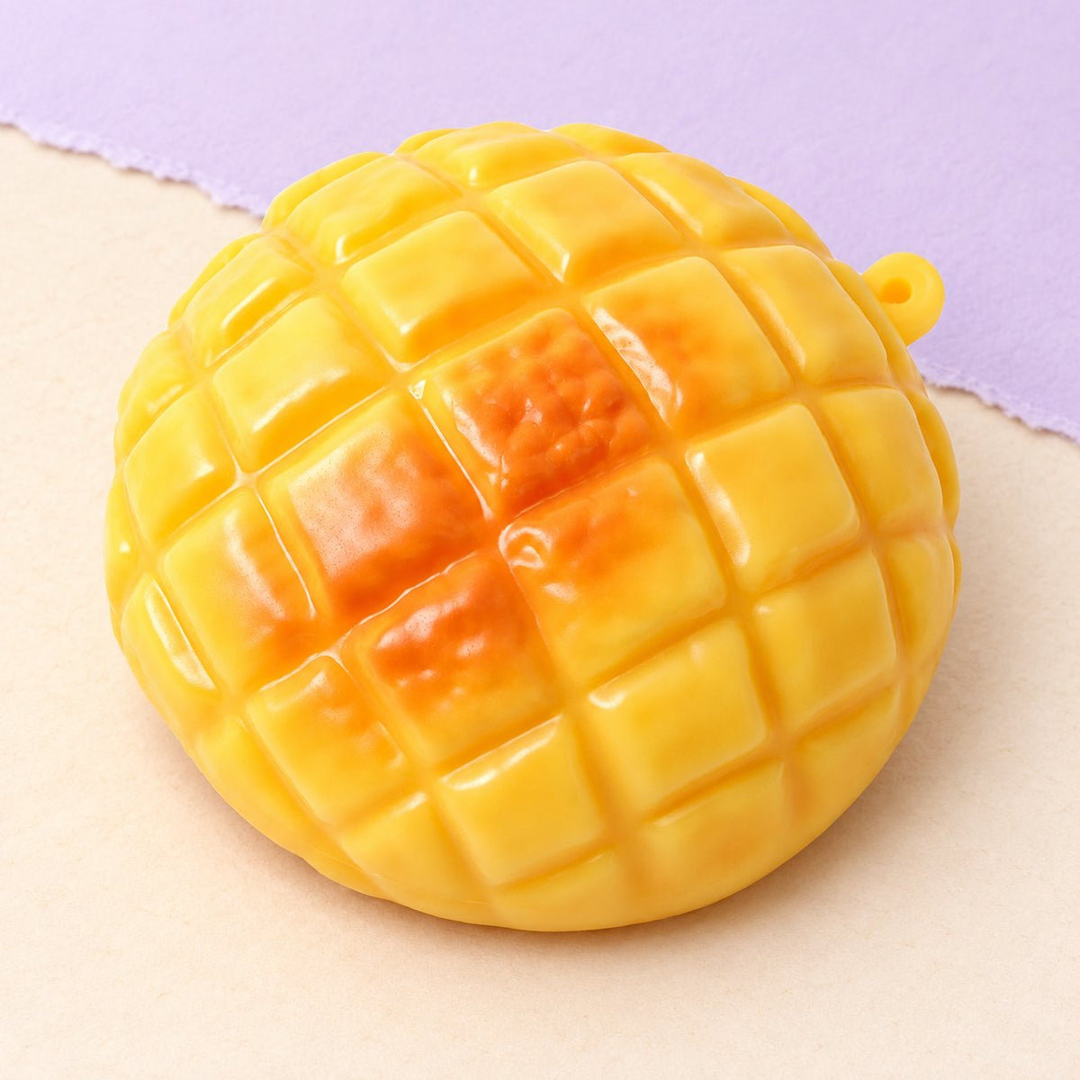 Squishy panino all'ananas da 9 cm, foto del prodotto su carta pastello