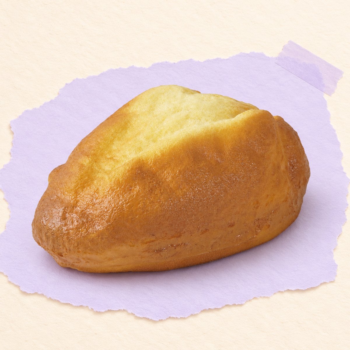 Squishy pão caseiro slow rising, dourado, com 16 cm, sobre papel cor pastel