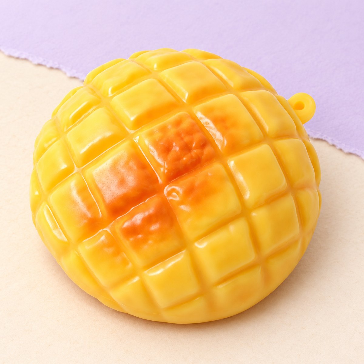 Squishy pão de ananás crunchy com 9 cm, sobre papel pastel