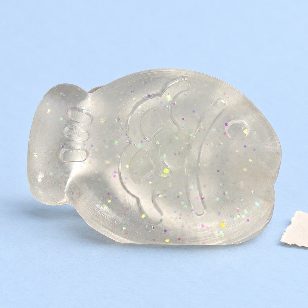 Squishy pesce mini da 6 cm, bianco con glitter, su carta pastello