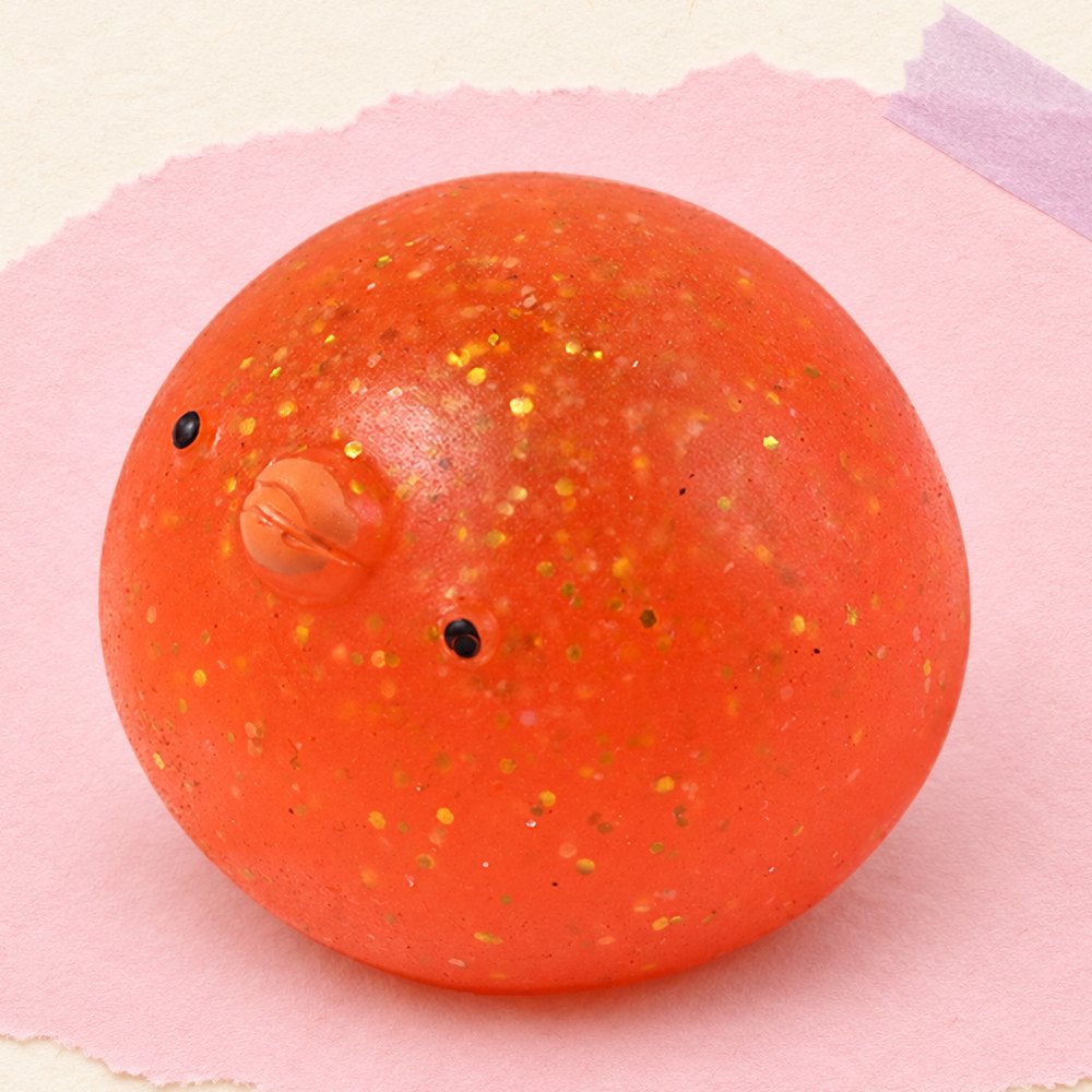 Squishy pintainho mochi com brilhantes, sobre papel pastel