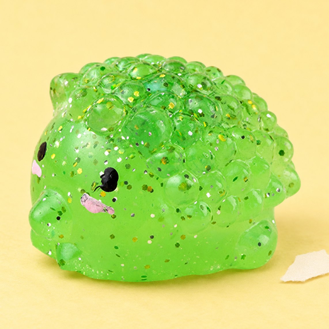 Squishy riccio con glitter fotografato su carta color pastello
