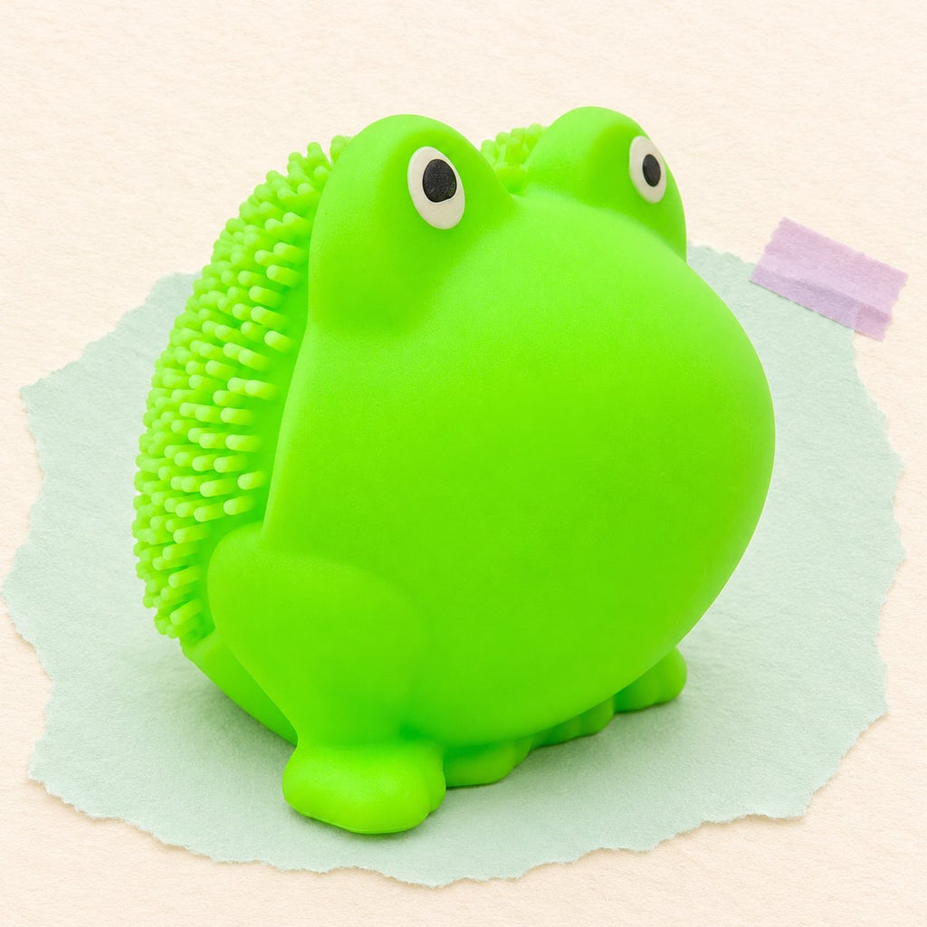 Squishy sapo com picos em TPR macio, 5 cm, sobre papel cor pastel