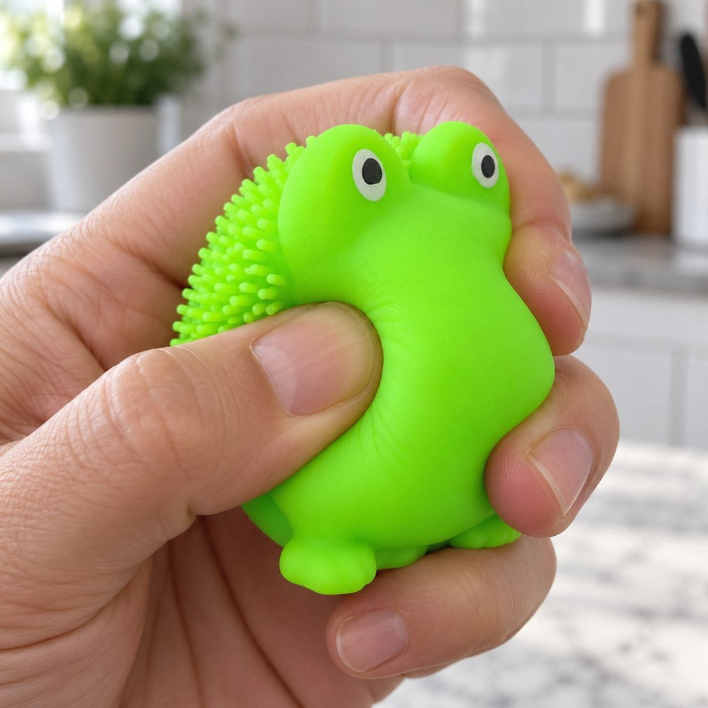 Mão a apertar o squishy sapo macio com picos