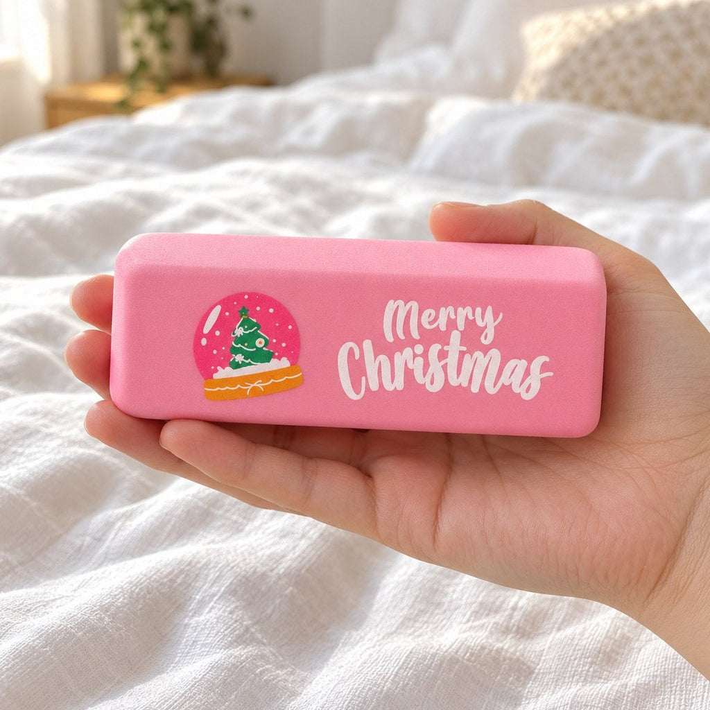 Squishy smør merry christmas i lyserød med snekugle, holdt i hånden