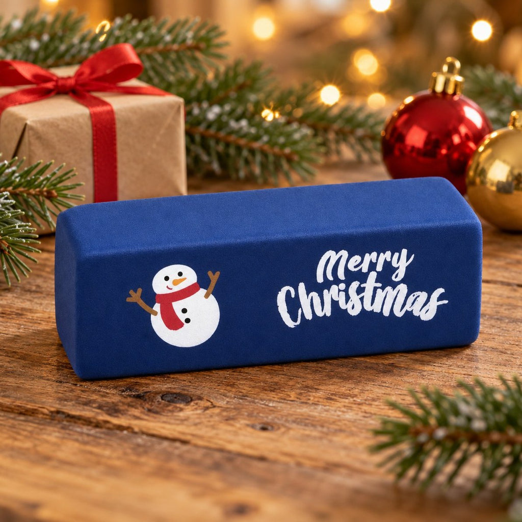 Squishy smør merry christmas i mørkeblå med snemand mellem grangrene og lyskæde