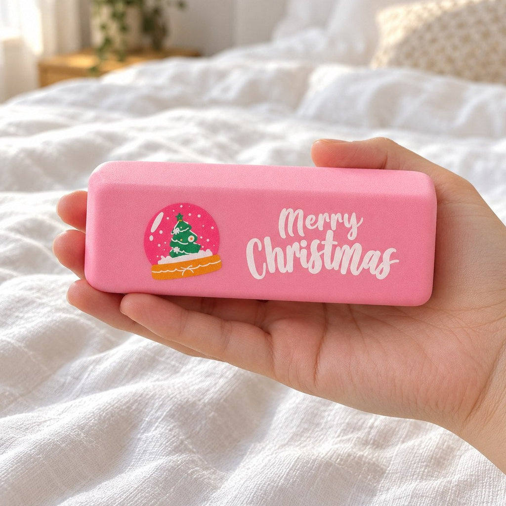 Hand som håller squishy smör Merry Christmas i rosa med snöglob, visar den verkliga storleken