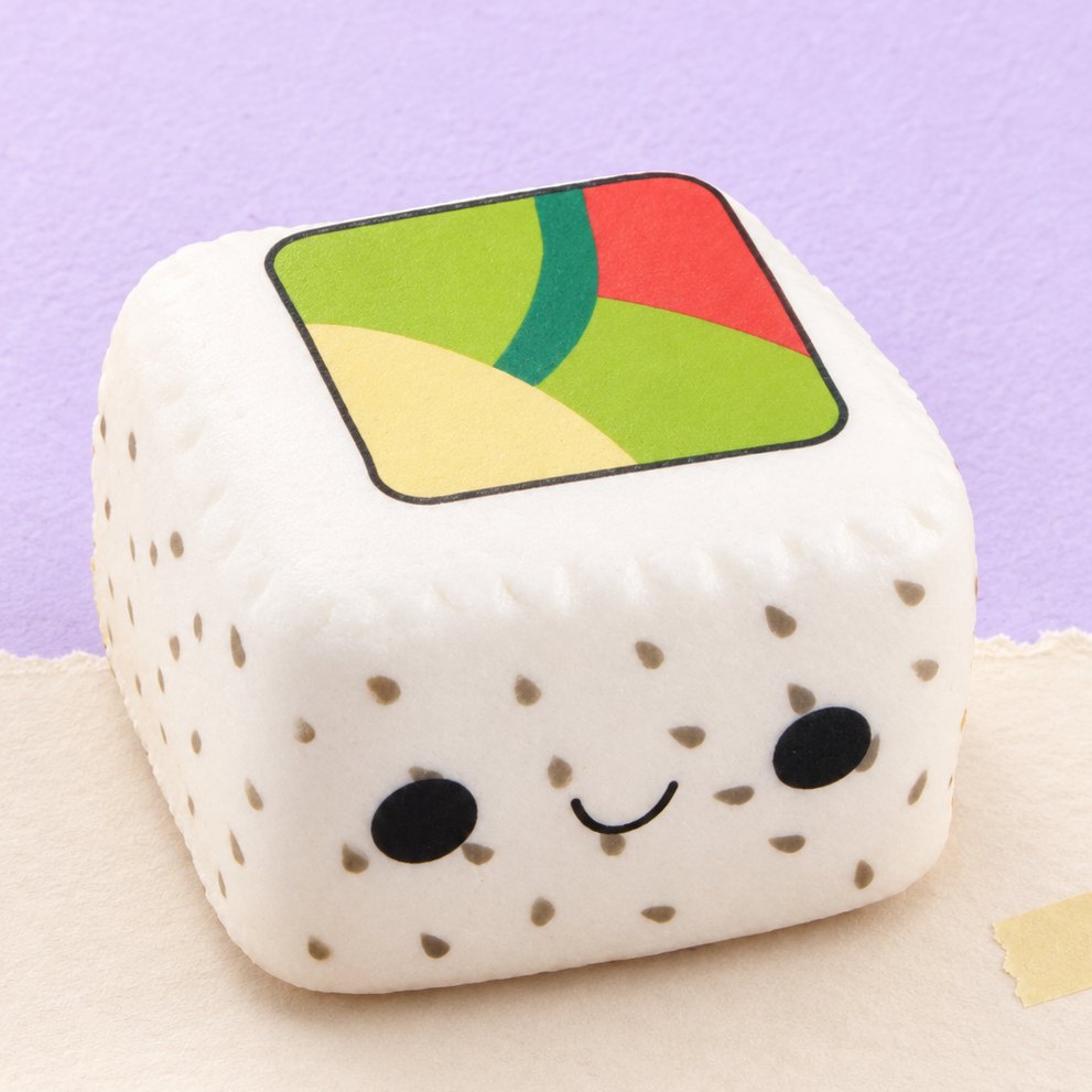 Squishy sushi kawaii slow rising, arroz branco com sésamo preto, sobre papel pastel
