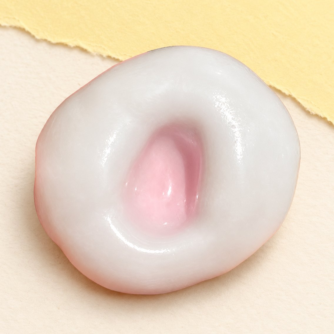 Squishy tortino di riso rosa fragola elastico fotografato su carta color pastello