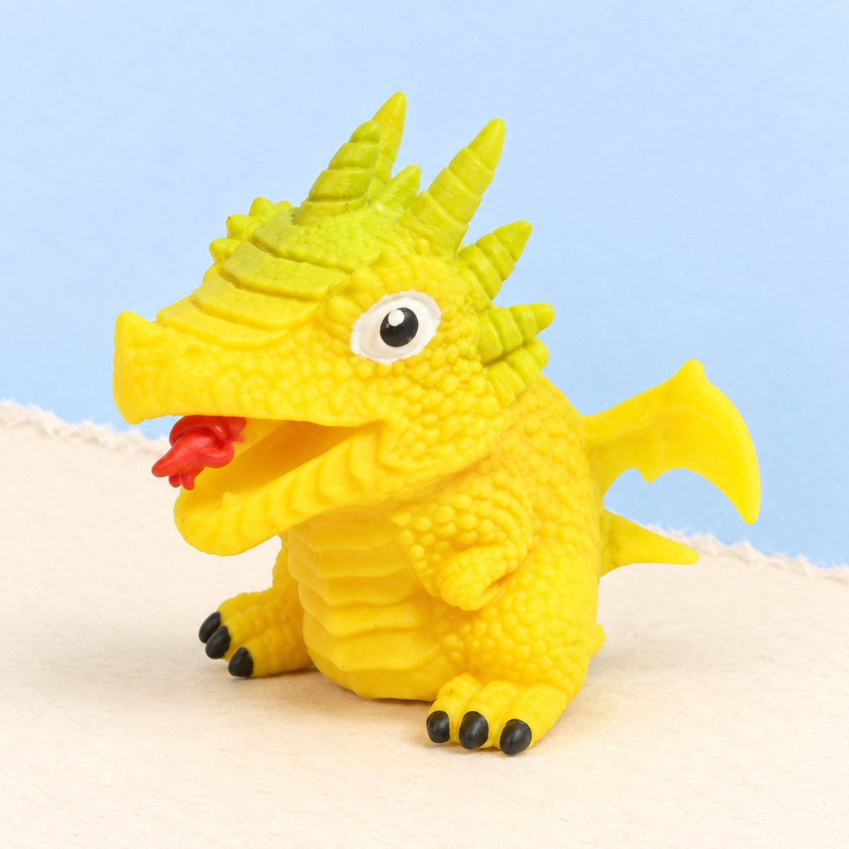 Squishy uovo di dinosauro reversibile giallo, dino casuale, su carta pastello