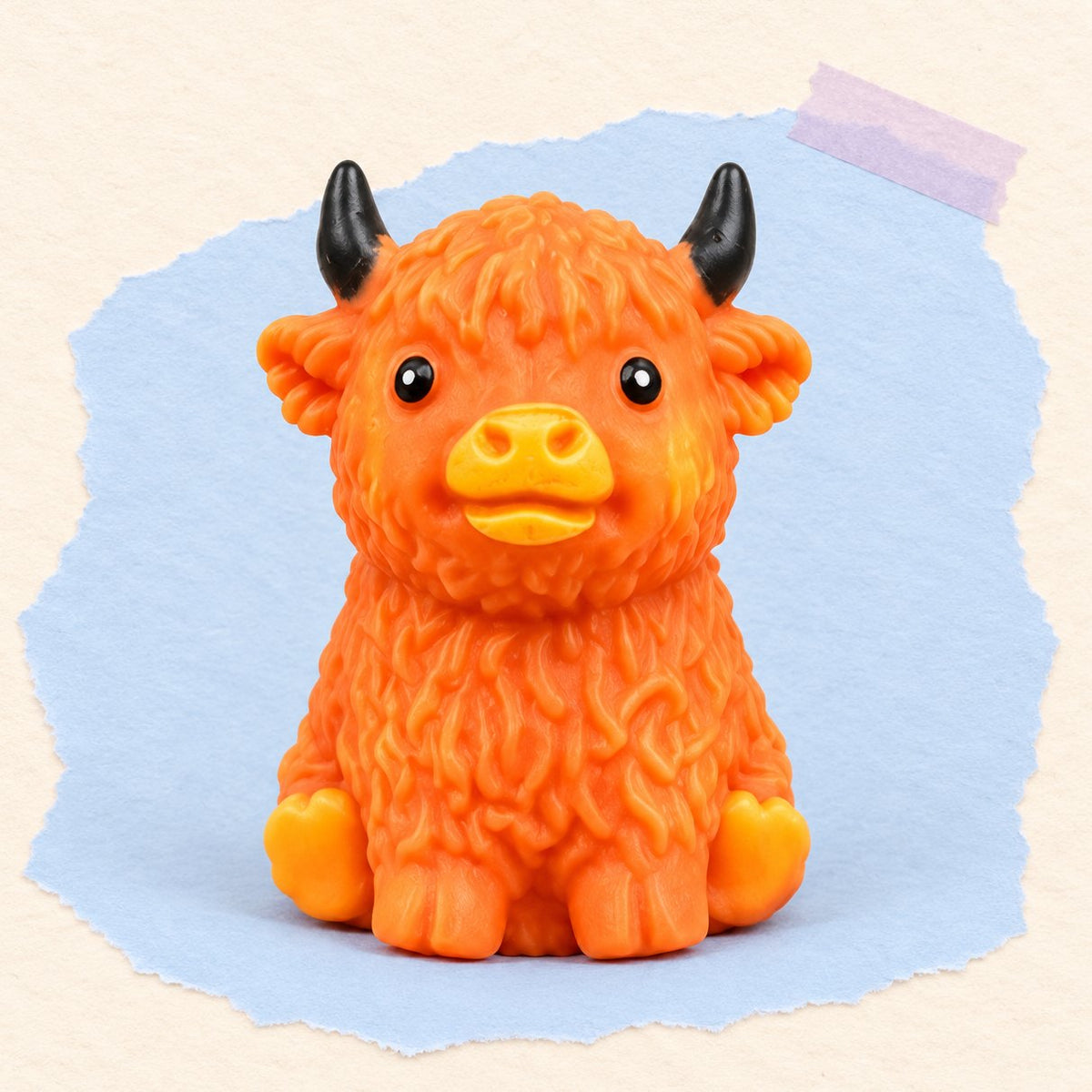 Squishy crunchy y blandito de vaca highland, marrón anaranjado, sobre papel pastel