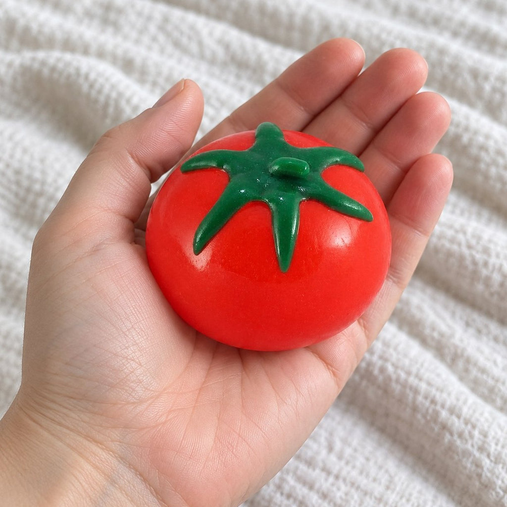 Z pohledu první osoby: squishy vodní ovoce rajče držené směrem k fotoaparátu
