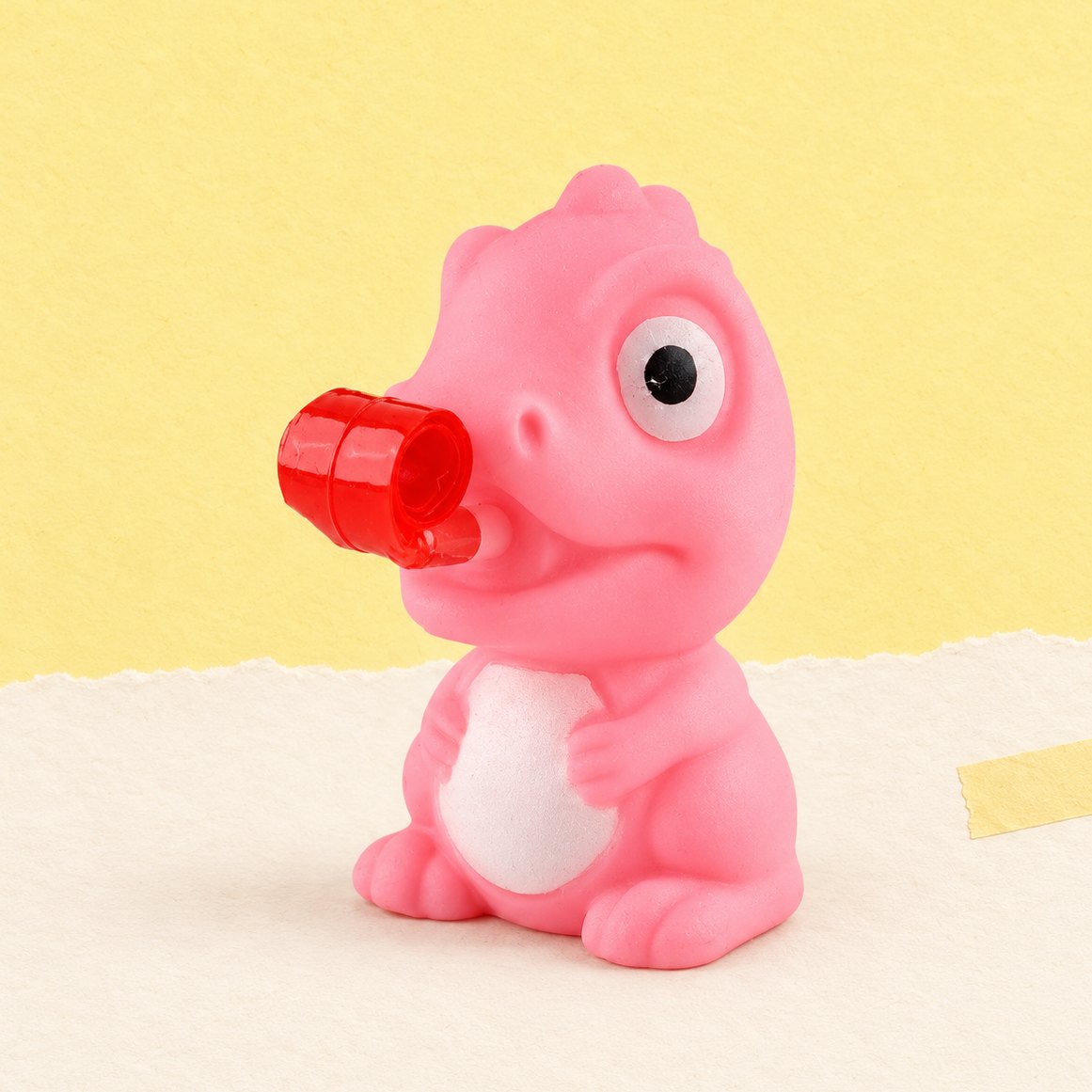 Squishy žabka nebo dino, varianta dino v náhodné barvě, na pastelovém papíře